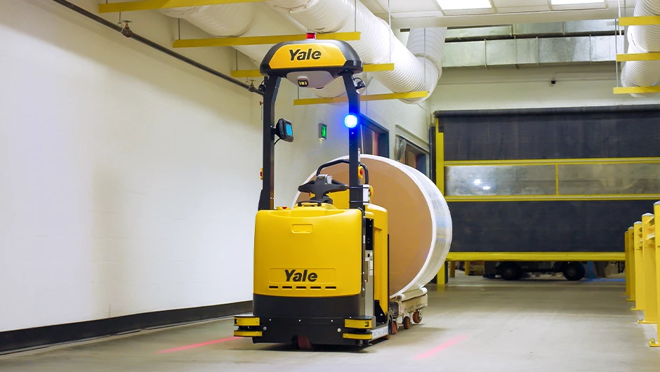 Yale Relay automated tow tractor pulling load in warehouse facility.
