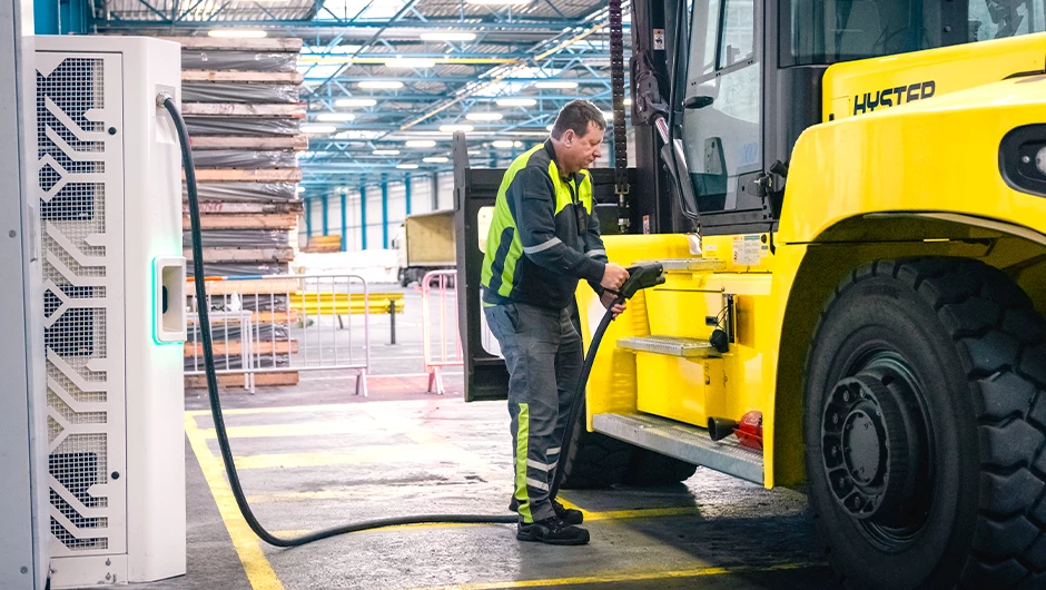 Man charging Hyster electric high-capacity lift truck.
